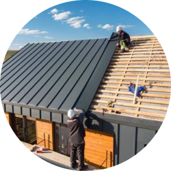 Construction workers installing a modern metal roof on a wooden house