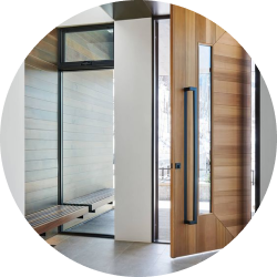 Modern entryway with large wooden pivot door and glass side panels